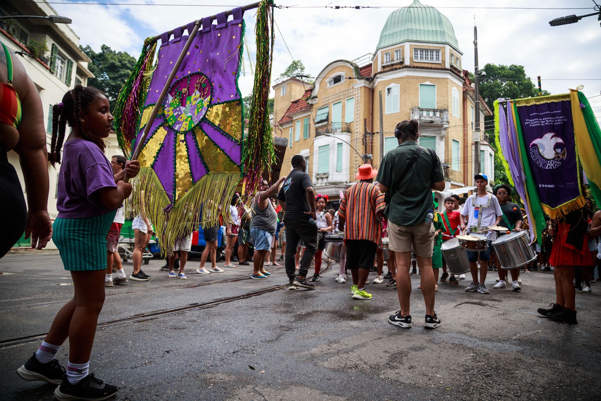 Cortejo de carnaval da Favela Brass com estandartes em 2026
